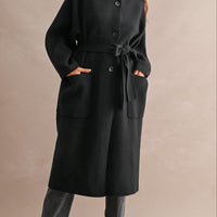 Women's black stand collar long coat with button-front closure, self-tie waist belt, and oversized patch pockets