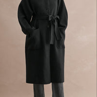Women's relaxed fit black belted long coat styled with charcoal jeans and black heeled boots