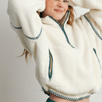 Cream sherpa fleece pullover featuring green zippered front pockets and adjustable hem
