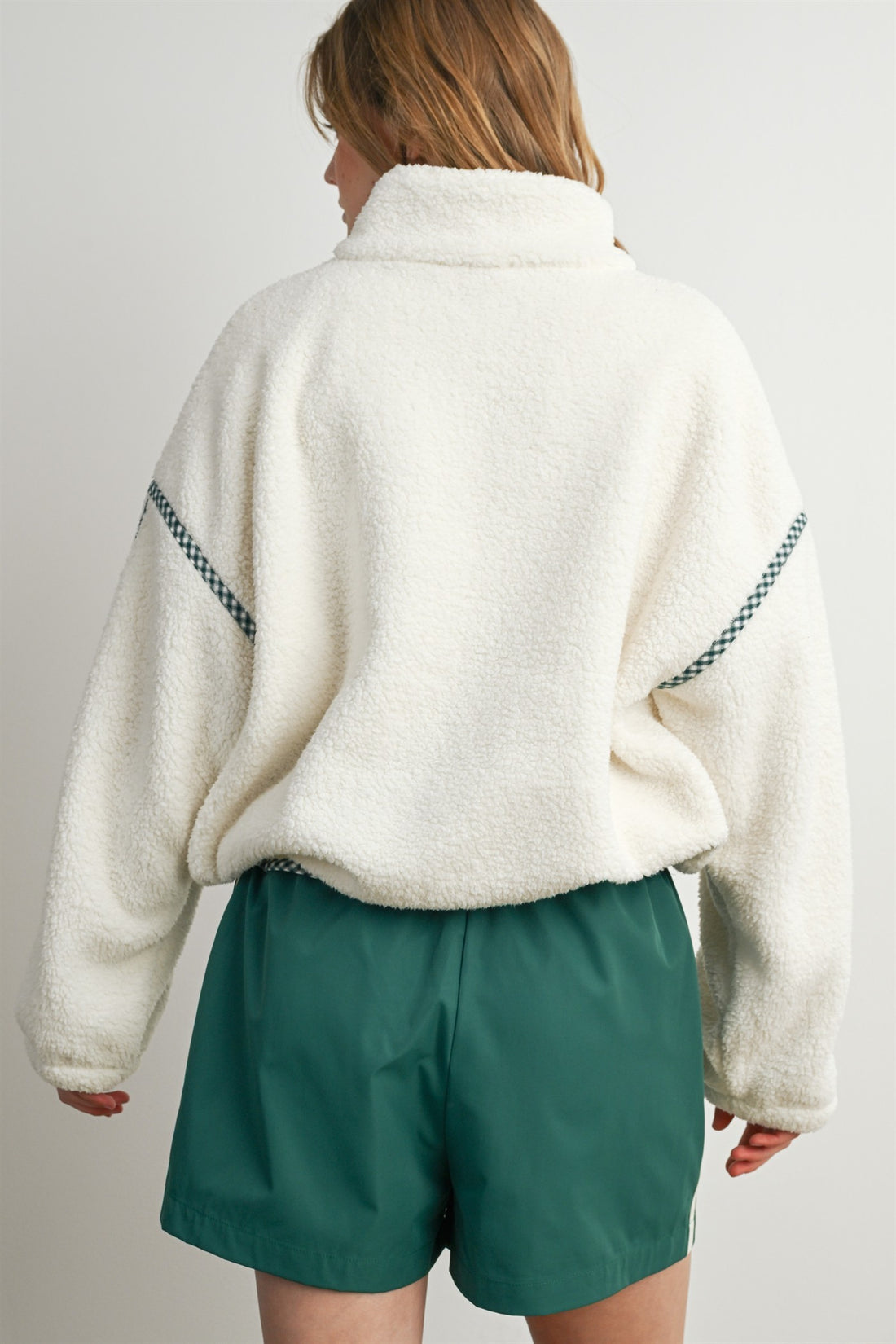 Back view of cream oversized sherpa fleece pullover with green gingham shoulder seam detailing