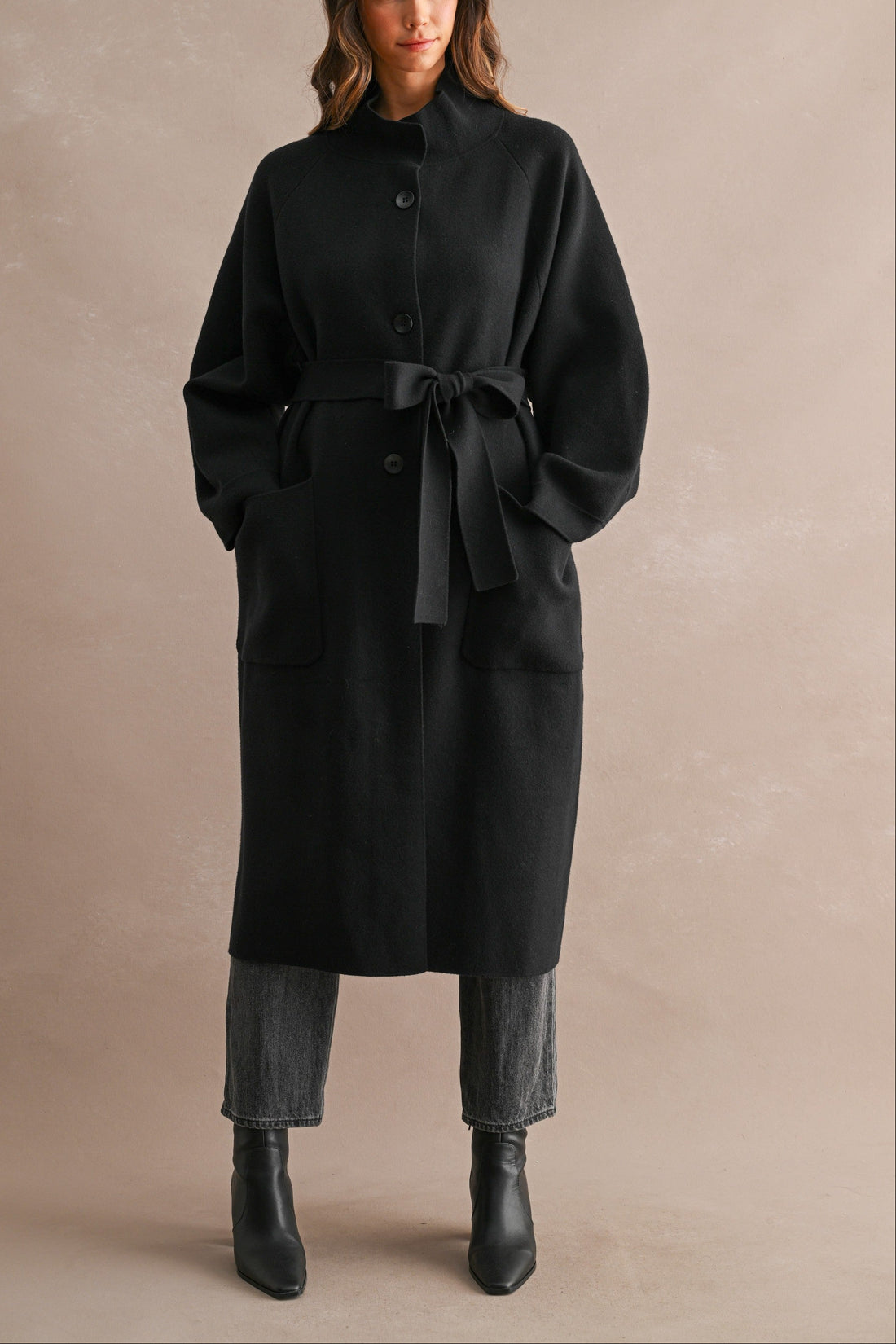 Women's black stand collar long coat with button-front closure, self-tie waist belt, and oversized patch pockets