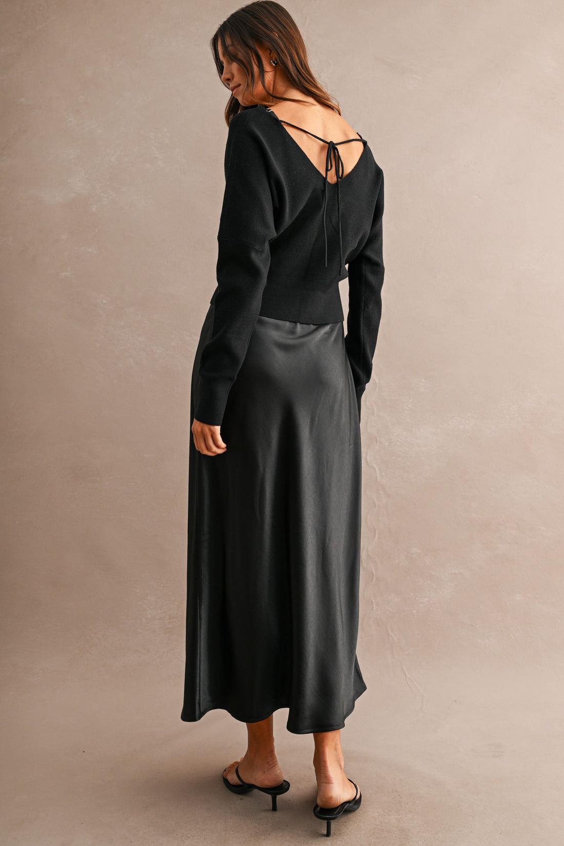 Back view of V-neck knit sweater with feminine tie-back detail