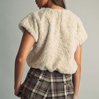 Back view of cream fluffy faux fur top with short sleeves and soft textured finish
