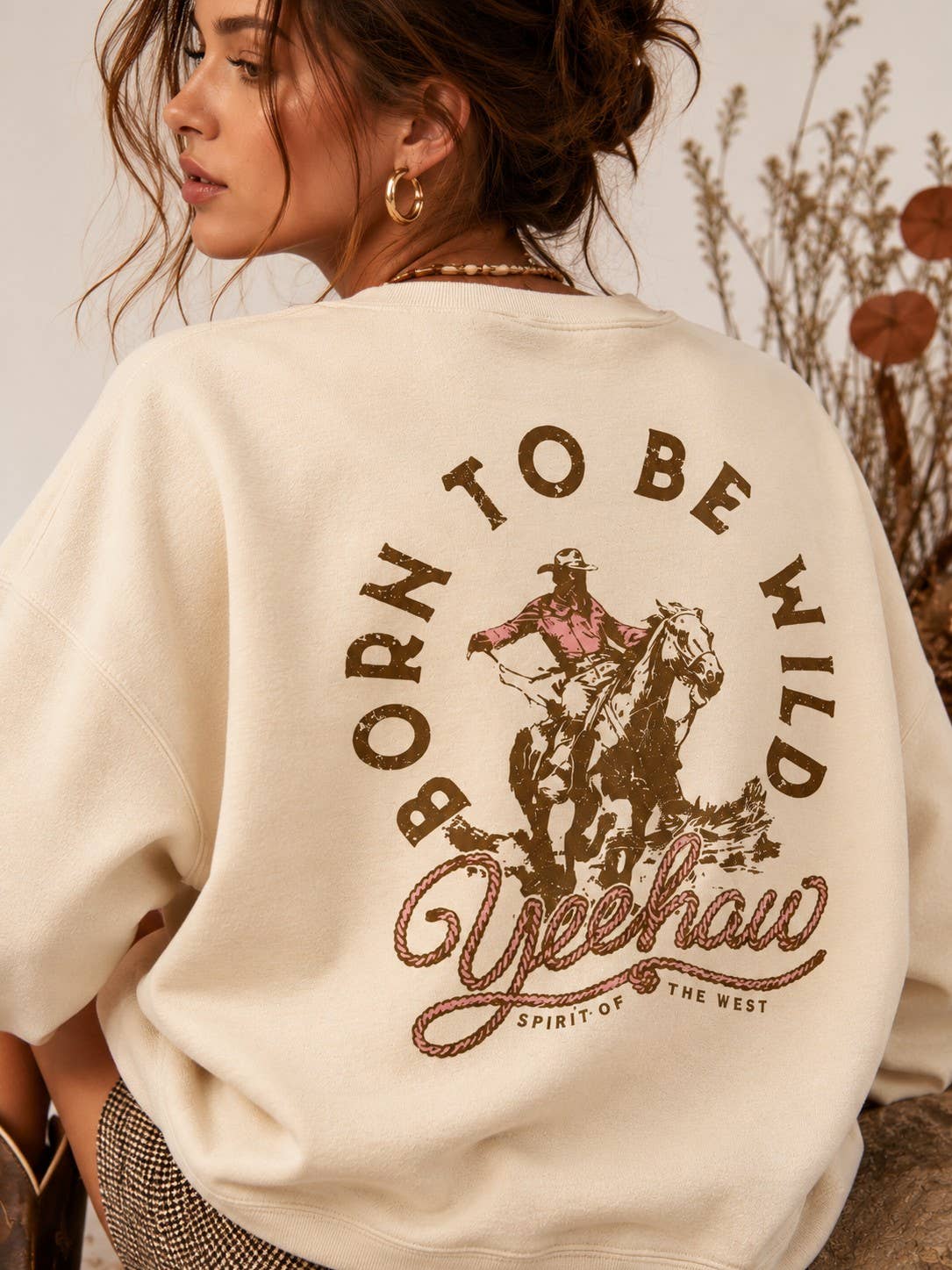 Close-up of the Born To Be Wild cowboy and horseback back graphic on the AFTERGLOW sweatshirt